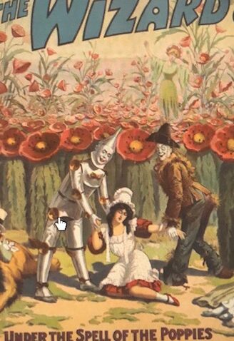 Tin man, Scarecrow, and Dorothy under a banner of poppies