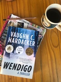Notebook, pencil, Wendigo book, and coffee cup