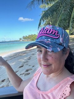 Woman on beach in a Guam baseball cap